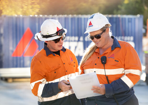 Photo of male and female Delta Group employees looking at paper work